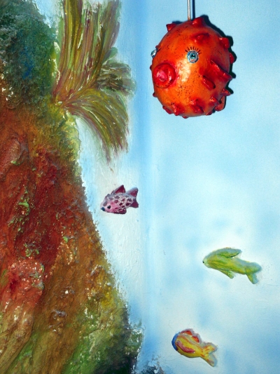 Roter Kugelfisch und kleine Fische am Riff